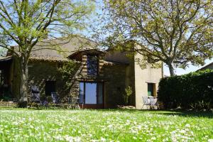 a house with a lawn with white flowers in front of it at La petite maison dans la prairie in Cassaignes