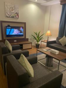 a living room with a couch and a tv at Swiss Blue in Jazan