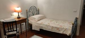 ペルージャにあるAgli Ippocastaniのベッドルーム1室(ベッド1台、ランプ付きテーブル付)