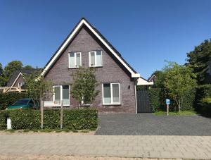 a brown brick house with a driveway at Geranio in Made