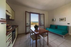 een woonkamer met een groene bank en een tafel bij Giallomare in Marzamemi