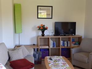 a living room with a couch and a tv at Idyllic Bungalow in Pepelow with Garden near Seabeach in Pepelow