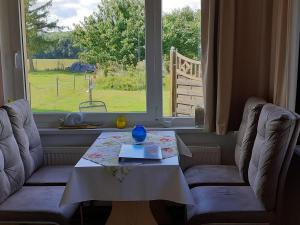 a table and two chairs in front of a window at Idyllic Bungalow in Pepelow with Garden near Seabeach in Pepelow
