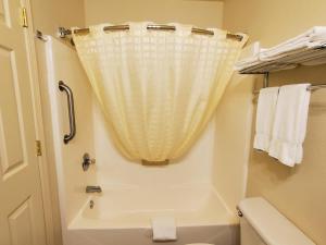 uma casa de banho com um WC e uma cortina de chuveiro em Candlelight Inn & Suites Hwy 69 near McAlester em McAlester
