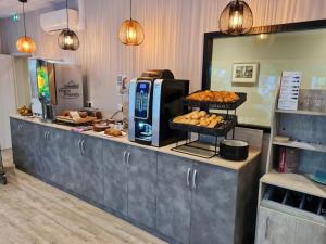 una panadería con un mostrador con pastas en Logis Hôtel l'Amandier en Morlaas