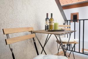 a table with two bottles and two glasses of wine at Stay Veszprèm, modern city center flat in Veszprém