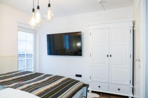 een slaapkamer met een bed en een tv aan de muur bij Club Alpenresidenz Gastein in Bad Gastein