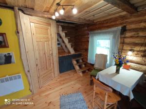 a room with a table in a wooden cabin at KUNDZINIŠĶI in Leitāni