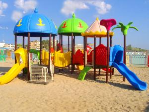 un parque infantil en la playa con coloridos equipos de juegos en Agenzia Vear - Osti 100, en Lido delle Nazioni