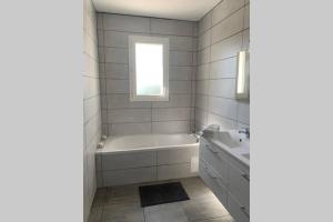 a white bathroom with a tub and a sink at Grande maison neuve idéale pour 6 personnes in Saint-Loubès +11 photos