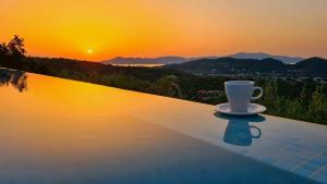 a coffee cup sitting on top of a swimming pool at Skiathos Garden Cottages in Skiathos Town