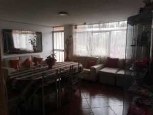- une salle à manger avec une table et un canapé dans l'établissement Hostal Turístico El Cajamarquez, à Lima