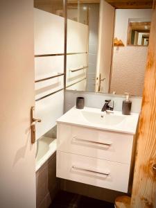 y baño con lavabo blanco y espejo. en Le Gypaète, en Chamonix-Mont-Blanc