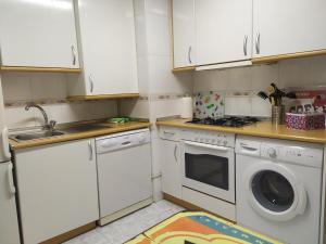cocina con armarios blancos y lavadora en Apartamento Poniente con dos baños centrico, en Logroño