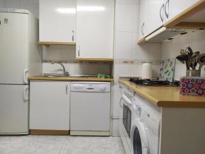 cocina con armarios blancos y lavavajillas en Apartamento Poniente con dos baños centrico en Logroño