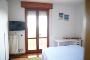 una camera con letto e porta scorrevole in vetro di Villa di agricoltori a San Costanzo