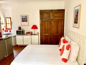 a bedroom with a white bed with a wooden door at le 1835, studio rouge-Corail in Moustiers-Sainte-Marie