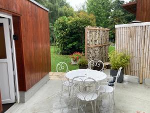 un patio con mesa, sillas y una valla en Residence Labrège T2Duplex Spa Piscine, en Sargé Les Le Mans 