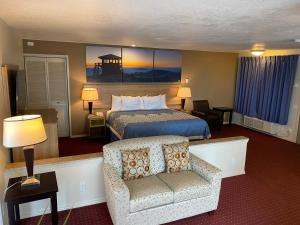 ein Hotelzimmer mit einem Bett und einem Stuhl in der Unterkunft Days Inn by Wyndham Newport OR in Newport