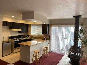 a kitchen with a stove and a counter with stools at Days Inn by Wyndham Newport OR in Newport
