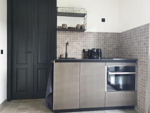 a kitchen with a counter with a sink and a microwave at Studio Bourbon in Veere