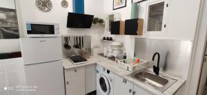 a white kitchen with a sink and a refrigerator at Huelintown in Málaga