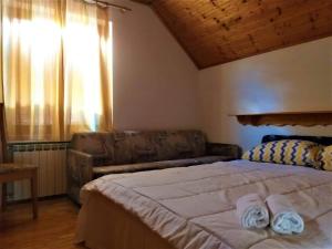 a bedroom with a large bed and a couch at Kuća za odmor Silver pine in Ogulin