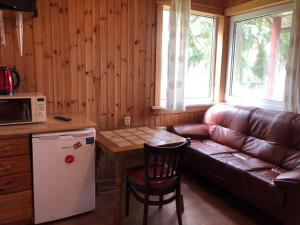 eine Küche mit Sofa, Tisch und Mikrowelle in der Unterkunft Baiļi in Valmiera