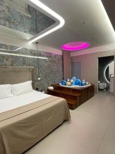 una camera con letto e soffitto rosa di Hotel 2000 a Giugliano in Campania