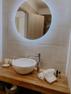 a bathroom with a bowl sink and a mirror at Mangata suites homes with private pools in Meganisi