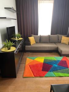 a living room with a couch and a colorful rug at ANK Summerland Mamaia in Mamaia