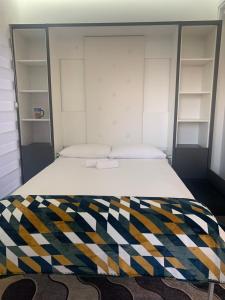 - une chambre avec un lit et une couverture colorée dans l'établissement Bar Exclusiv Soho city Residence, à Bar
