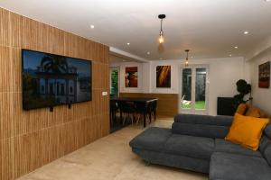ein Wohnzimmer mit einem Sofa und einem Tisch in der Unterkunft La maison penchée in Rosny-sous-Bois
