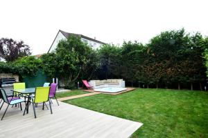 eine Terrasse mit Stühlen und einem Tisch im Hof in der Unterkunft La maison penchée in Rosny-sous-Bois