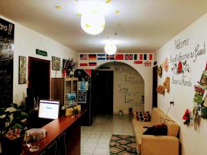 ヴロラにあるVlora Backpackers Hostel & Bar LUNGOMAREのデスク付きのオフィスとソファ付きの部屋