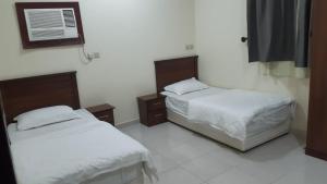 a bedroom with two beds and a air conditioner at شقق لانا ينبع in Yanbu