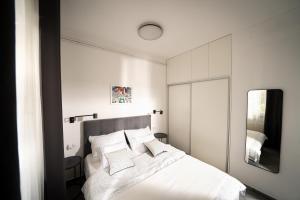 a bedroom with a white bed and a mirror at Amalis in Rijeka