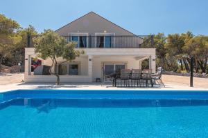 a villa with a swimming pool in front of a house at Lovely view villa in Povlja in Povlja