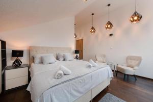 um quarto com uma grande cama branca e 2 cadeiras em Lovely view villa in Povlja em Povlja