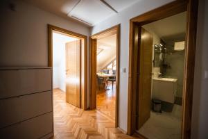 um corredor com uma casa de banho com um lavatório e um espelho em Avila Apartments em Sarajevo