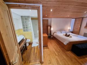 レ・ズッシュにあるChalet Tontine, 3 bedrooms, sauna, terrace and great views !のベッドと浴槽と洗面台のある寝室