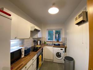 a kitchen with a sink and a washing machine at Marie’s Serviced Apartment 2 bed Olivier Court in Bedford