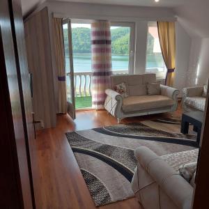 ein Wohnzimmer mit einem Sofa und einem großen Fenster in der Unterkunft Villat Pqrku i Lqenit in Orllan