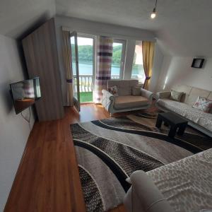 ein Wohnzimmer mit einem Sofa und einem TV in der Unterkunft Villat Pqrku i Lqenit in Orllan