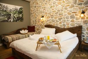 Una habitación de hotel con una cama con una bandeja de comida. en Très Belle en Korçë
