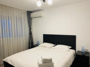 Un dormitorio con una cama blanca con toallas. en Apartament Cristina, en Bucarest