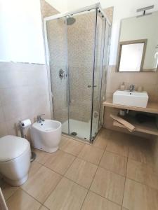 een badkamer met een douche, een toilet en een wastafel bij Piccolo Ulivo B&B Salento in Vernole
