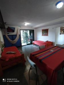 a room with two beds and a table and chairs at Rancho Taxco in El Pueblito