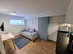 ein kleines Wohnzimmer mit Sofa und Fenster in der Unterkunft Apartament Łąki18 in Wadowice