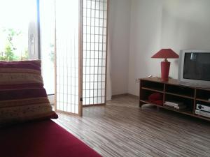 a living room with a television and a table with a lamp at Ferienappartement in St. Margarethen in Sankt Margarethen im Burgenland